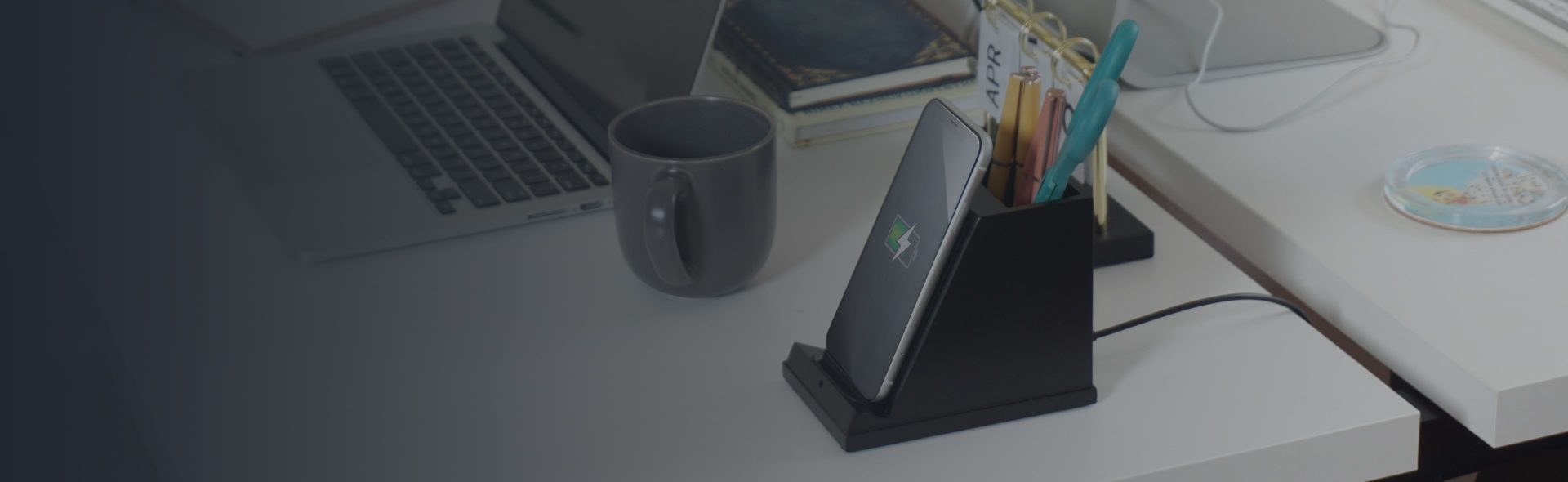 A phone is sitting on top of a charging station, on top of a desk